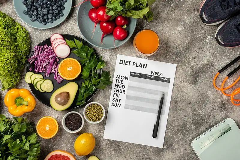 table with fresh fruits and veggies with diet planner