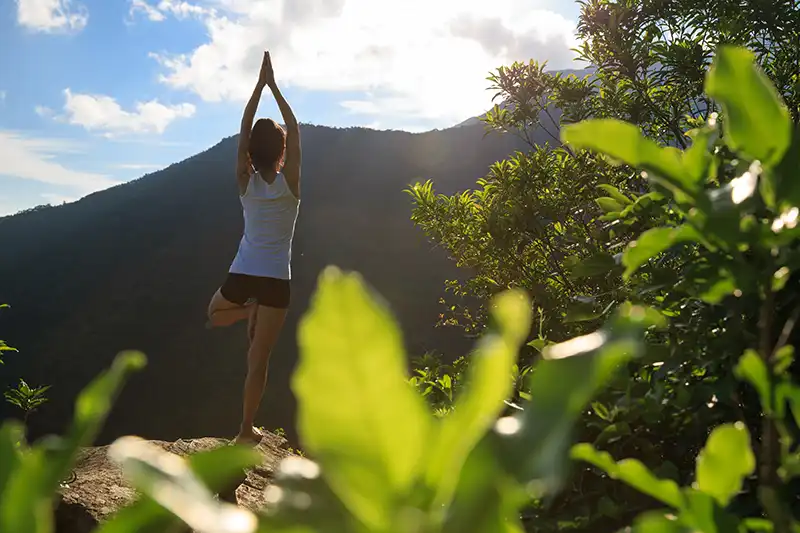 Woman Doing Sunrise Yoga on Mountain Top